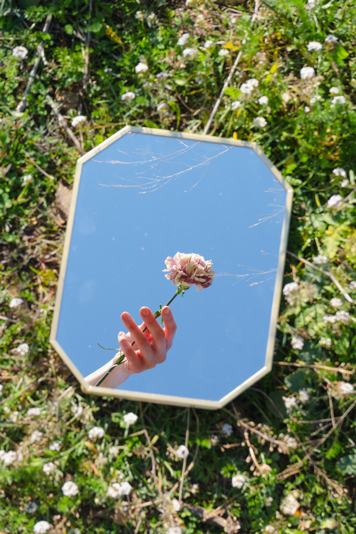 Hand with Flower Reflected in Mirror